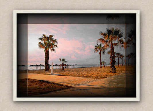 Landscape artwork of a beach and palm trees; with dark borders and white frame, on a beige wall