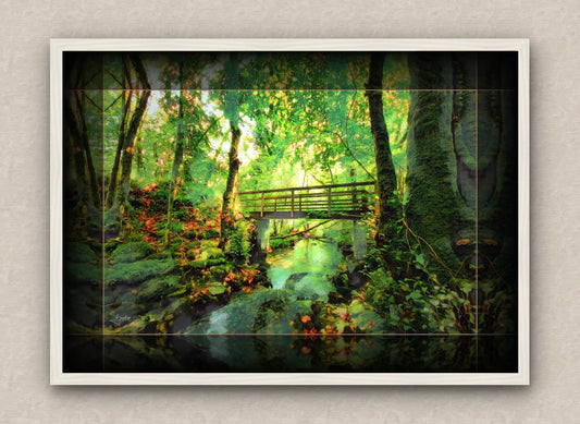 White framed wall art painting of a lush green forest with a bridge over a stream