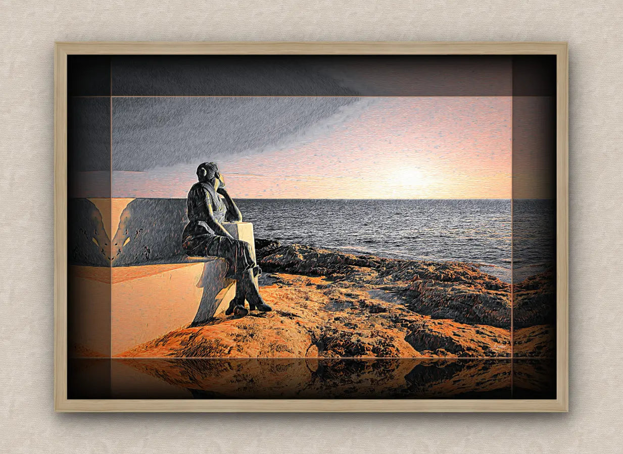 Oak framed seascape artwork depicting a statue of a woman sitting on a bench by the ocean at sunrise.