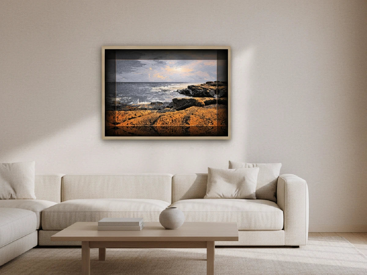 Framed artwork of a coastal scene above a white sofa in a living room.