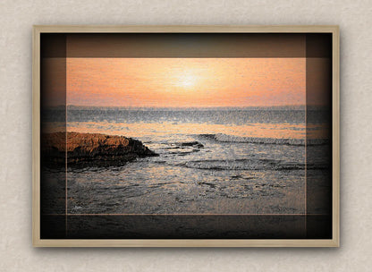 Oak frame artwork of a sunrise over the sea with rocks and waves in the foreground.