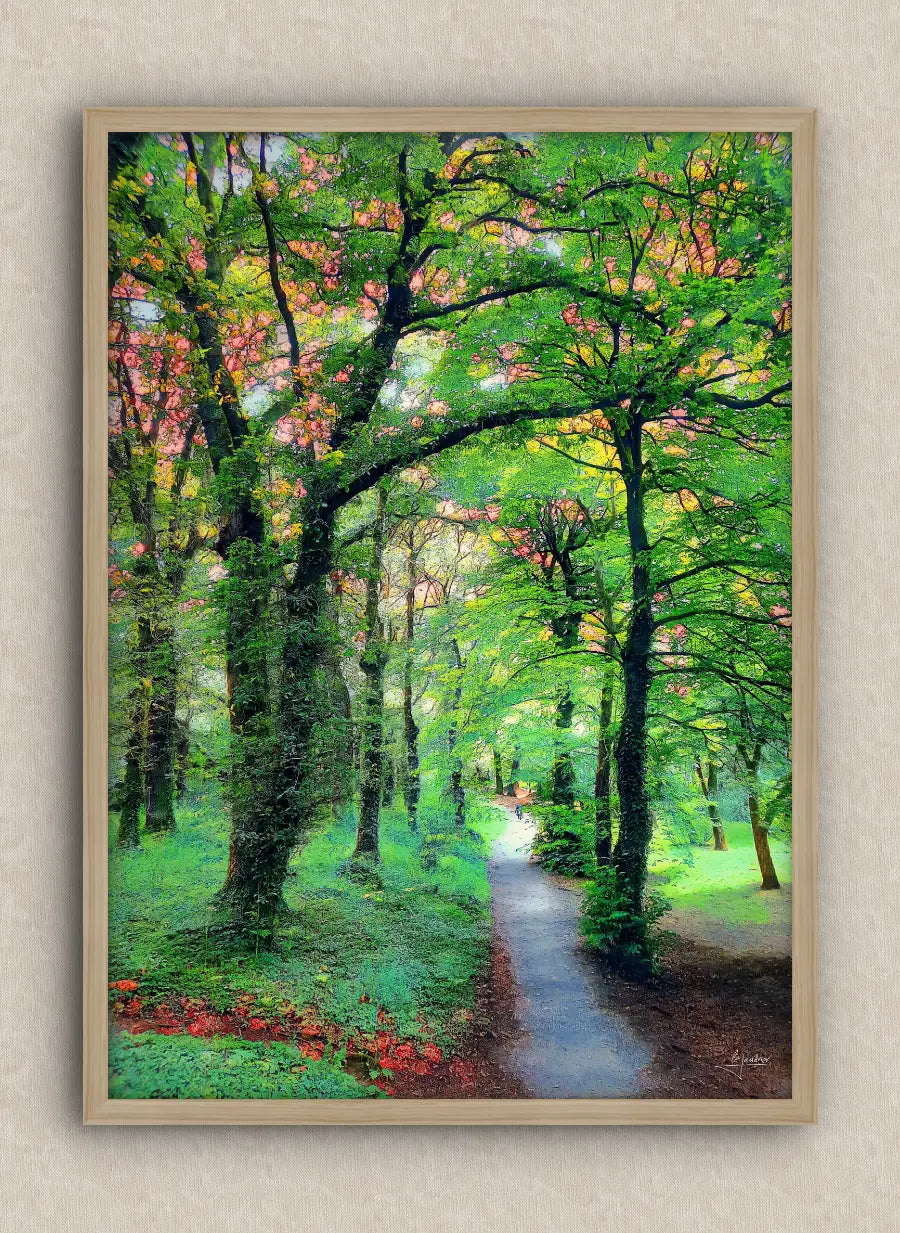 Wall artwork consisting of a landscape in portrait with a lush green forest and a path, framed in oak